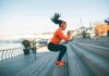 This Might Be The Key To Following Through With Health Goals Woman exercising on outdoor steps by a riverside