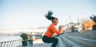 Woman exercising on outdoor steps by a riverside
