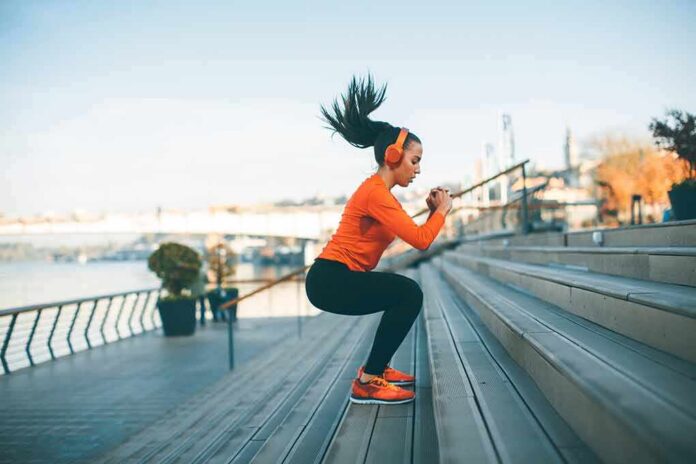 Woman exercising on outdoor steps by a riverside