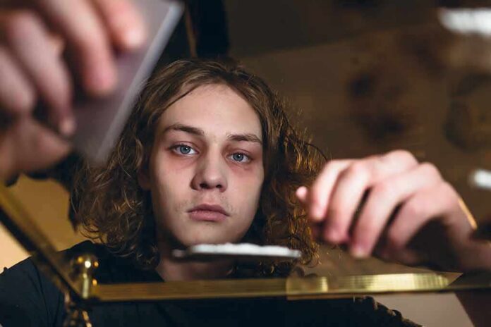young person leaning over a table with hands arranging items