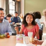 Students eating lunch together at a cafeteria table