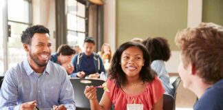 Students eating lunch together at a cafeteria table