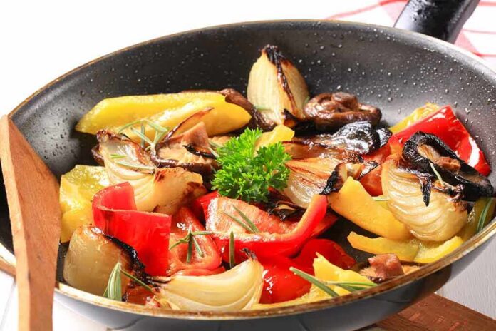 shutterstock_113282938 A skillet filled with colorful stir-fried vegetables including onions and bell peppers