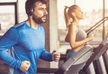 Man in blue long-sleeve running on a treadmill with headphones