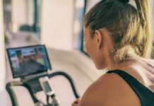 How Much Weight You Can Actually Lose in a Week Woman on stationary bike watching a screen
