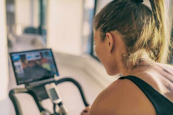 Woman on stationary bike watching a screen