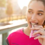 Woman eating a granola bar outdoors