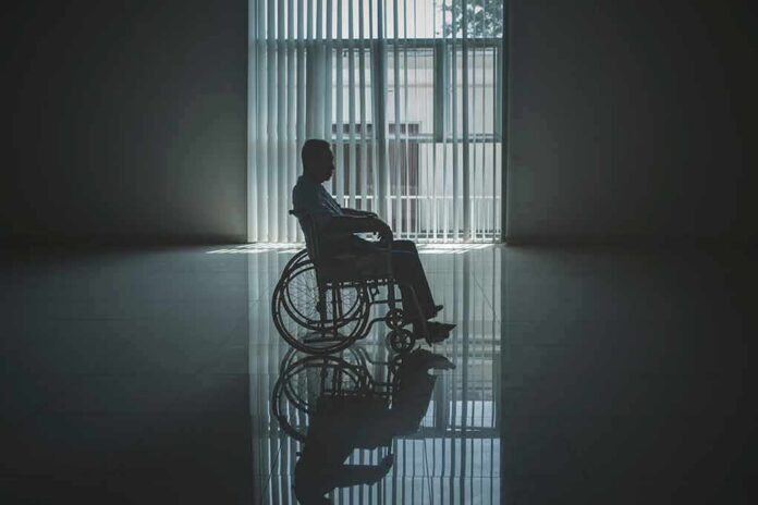 Person in a wheelchair silhouetted by a large window
