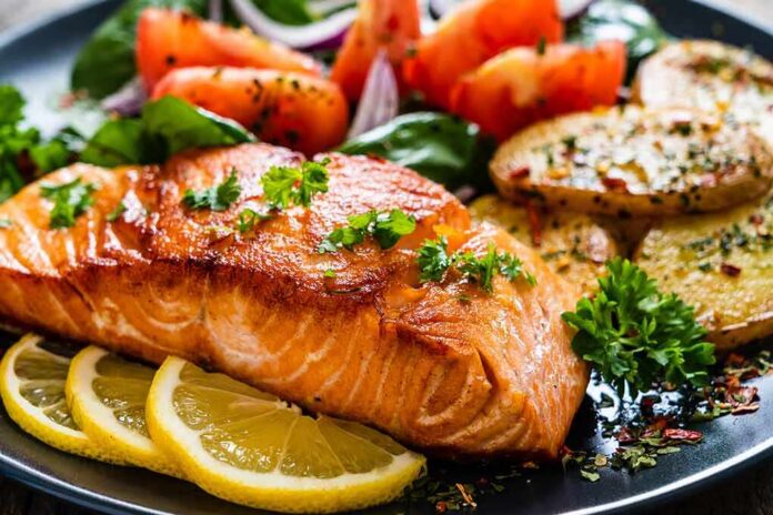 Seared salmon fillet with lemon slices and vegetables