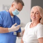 Smiling woman receiving a vaccination from a healthcare worker