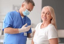 FDA Roadblock Freezes Longevity Breakthrough Smiling woman receiving a vaccination from a healthcare worker