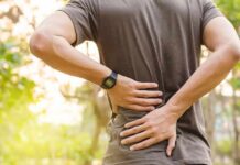 person holding lower back outdoors