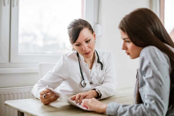 shutterstock_796803439 Doctor consulting a patient at a desk