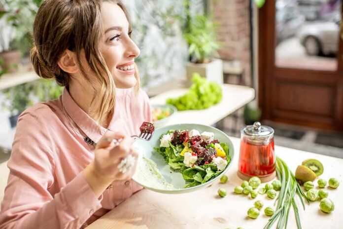 1783890419426-debefy-shutterstock-1028139997 Woman eating a fresh salad at a bright cafe