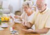 Older couple organizing medication at a kitchen table