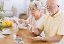 Older couple organizing medication at a kitchen table
