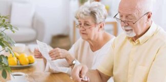 Older couple organizing medication at a kitchen table