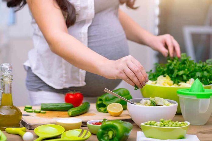 shutterstock_1038118966 Person preparing a fresh salad with green vegetables in a kitchen
