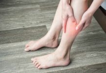 person holding calf with red area indicating leg pain