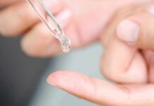 Derm Docs Drop Retinol Bombshell dropper applying clear liquid to fingertip