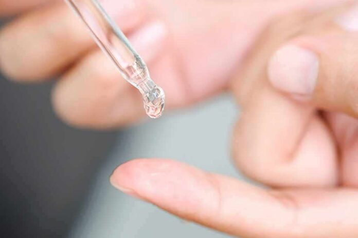 shutterstock_1470246686 dropper applying clear liquid to fingertip