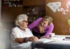 Elderly woman and younger woman smiling at a table