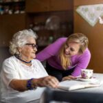 Elderly woman and younger woman smiling at a table