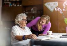 Elderly woman and younger woman smiling at a table