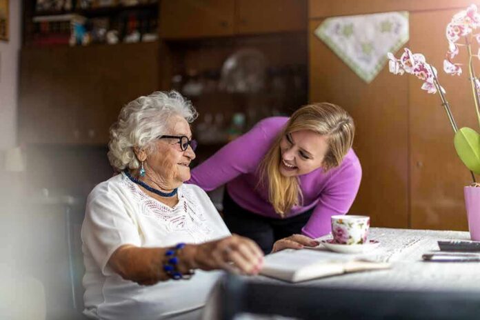 Elderly woman and younger woman smiling at a table