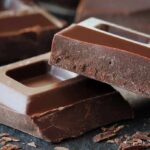 Dark chocolate: A workout performance booster? Chocolate bars with rough edges on a dark surface