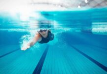 Swimmer’s Itch vs Chlorine Burn swimmer underwater in a lane pool