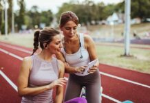 1 Exercise Detail Could Make A Bigger Difference For Your Brain Two women at a running track looking at a tablet