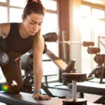 Woman performing dumbbell row in a gym