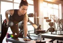 Woman performing dumbbell row in a gym