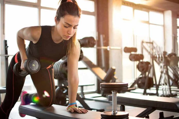 shutterstock_401309230 Woman performing dumbbell row in a gym