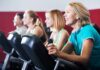 group of people cycling on exercise bikes at a gym