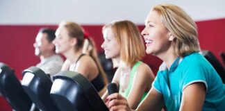 group of people cycling on exercise bikes at a gym