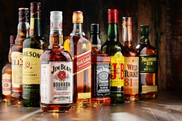 shutterstock_538308844 Assorted whiskey bottles arranged on a wooden surface