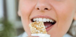 Person taking a bite of a granola bar