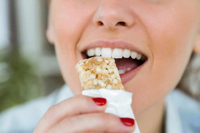 Person taking a bite of a granola bar