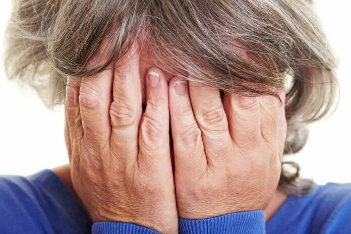 person covering their face with both hands