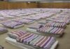 Men’s Health 2026 Sleep Awards rows of mattresses with striped bedding in a large hall