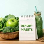 Basket of green vegetables with apple, notebook, and green smoothie