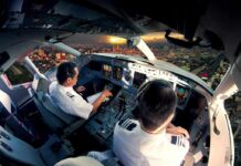 How Frequent Flyers Hit Dangerous Radiation Zones Pilots in an airplane cockpit during city approach at sunset