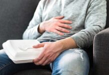 Cancer Flags Found in Everyday Food Packaging Person holding takeout container while touching stomach