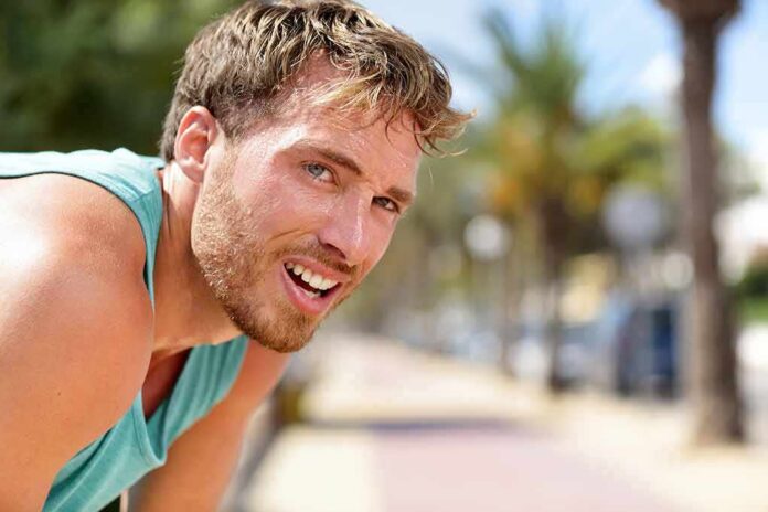 shutterstock_1017406066-1 man in athletic tank top resting outdoors