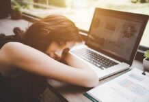 Scary Nap Pattern Flags Hidden Illness Woman resting her head on desk beside an open laptop