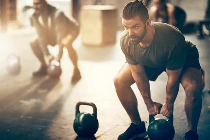 Man lifting kettlebell in gym