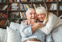 Older couple hugging and laughing on a couch