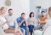 Massive Study Upends Happiness Playbook Support group meeting with six adults seated in a circle